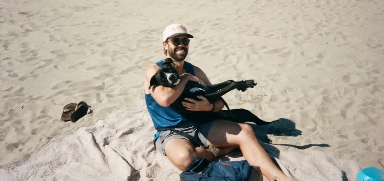 Evan Tarver at the beach holding his dog